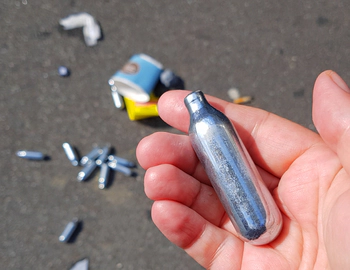 Person holds laughing gas can