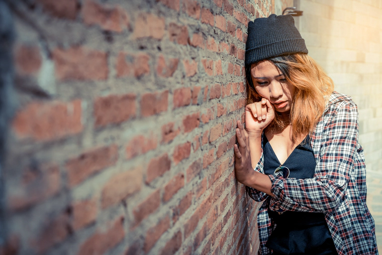 Teenager sitting by the wall