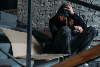 Heroin addict sits on a staircase