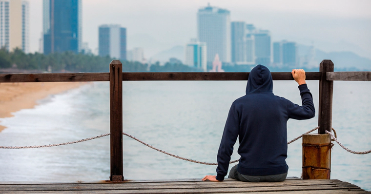 Man sits on a bridge