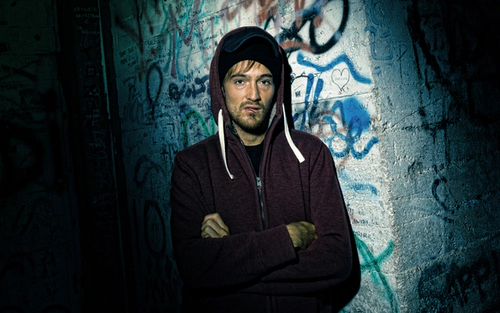 Man living on the streets in front of graffiti